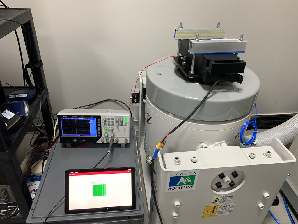 The test setup, with the vibration pot, the battery under test, and an oscilloscope to detect cell disconnections.